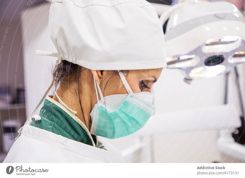 Frau in medizinischer Maske und Kittel in einer Klinik Arzt Mundschutz behüten Krankenhaus Arbeit beschäftigt Praktiker Uniform Spezialist hell modern Personal
