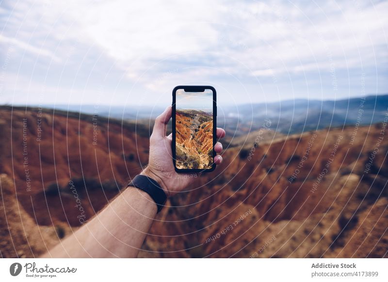Reisende, die mit ihrem Smartphone ein Foto von den Bergen macht Reisender Berge u. Gebirge fotografieren Erosion Hand Telefon wild Natur Landschaft männlich