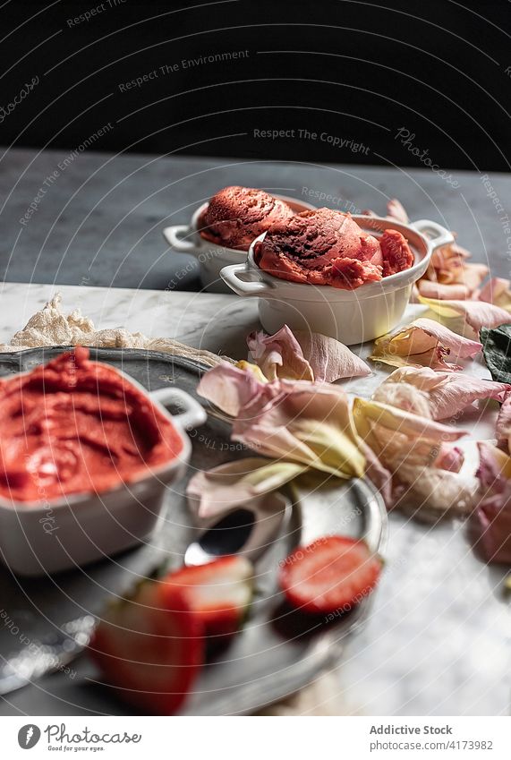 Leckeres Erdbeersorbet auf einem Tisch mit Rosenblüten Dessert Erdbeeren Sorbet rosa süß dienen Portion Lebensmittel Farbe Roséwein Exquisit Blume Beeren lecker