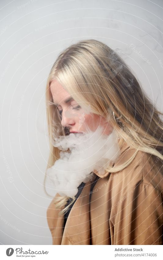 Junge Frau raucht e-Zigarette im Studio e Zigarette Raps Rauch Atelier Verdunstung Stil cool Nikotin Raucherin Habitus selbstbewusst jung schlecht ungesund