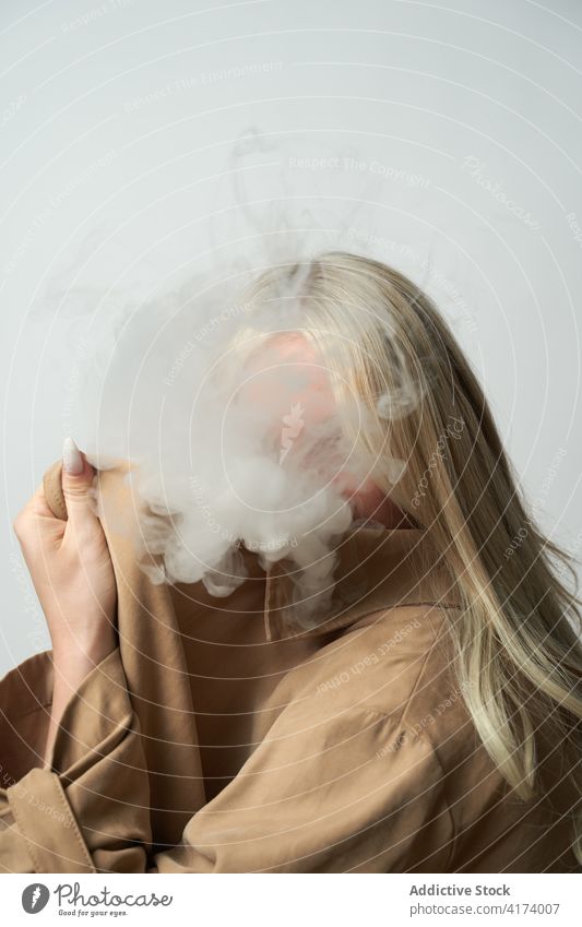 Anonyme Frau im Studio von Rauch bedeckt Deckung e Zigarette Raps Atelier Verdunstung Stil cool Nikotin Raucherin Habitus selbstbewusst schlecht ungesund