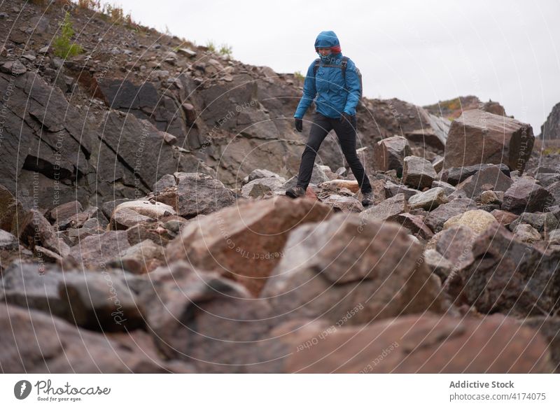 Reisende Frau beim Wandern in felsigem Terrain Trekking Wanderung Wanderer Felsen Gelände erkunden Herbst warme Kleidung Entdecker reisen Natur wolkig Urlaub