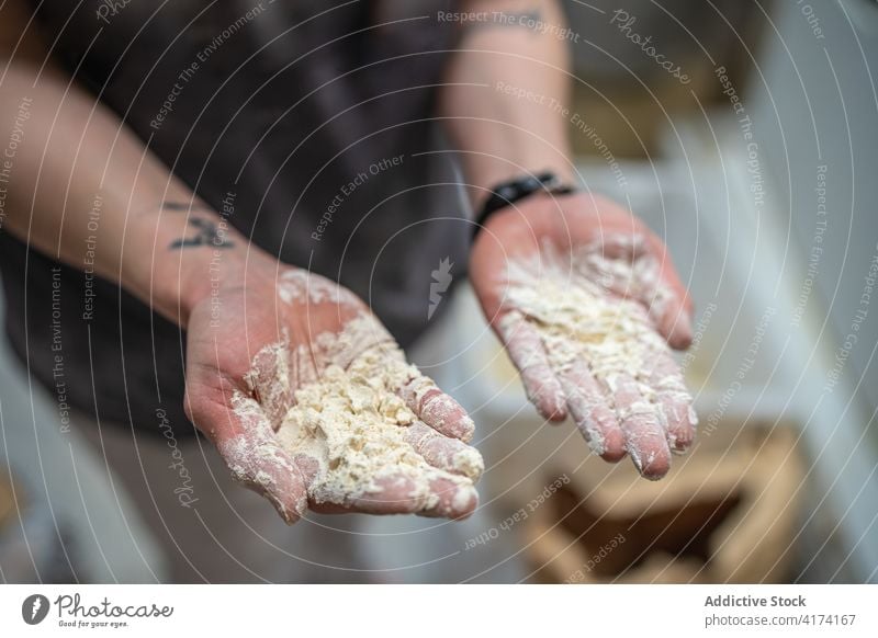 Crop-Bäcker mit Teig an den Händen Teigwaren Hand Bäckerei dreckig unordentlich Mehl Arbeit Küche vorbereiten Lebensmittel Gebäck kulinarisch Küchenchef frisch