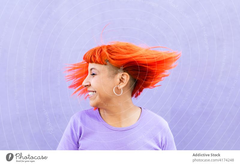Entzückte Frau schüttelt rotes Haar Haare schütteln Glück Stil auflehnen gefärbtes Haar Ingwer Spaß farbenfroh hell Erwachsener tausendjährig Subkultur
