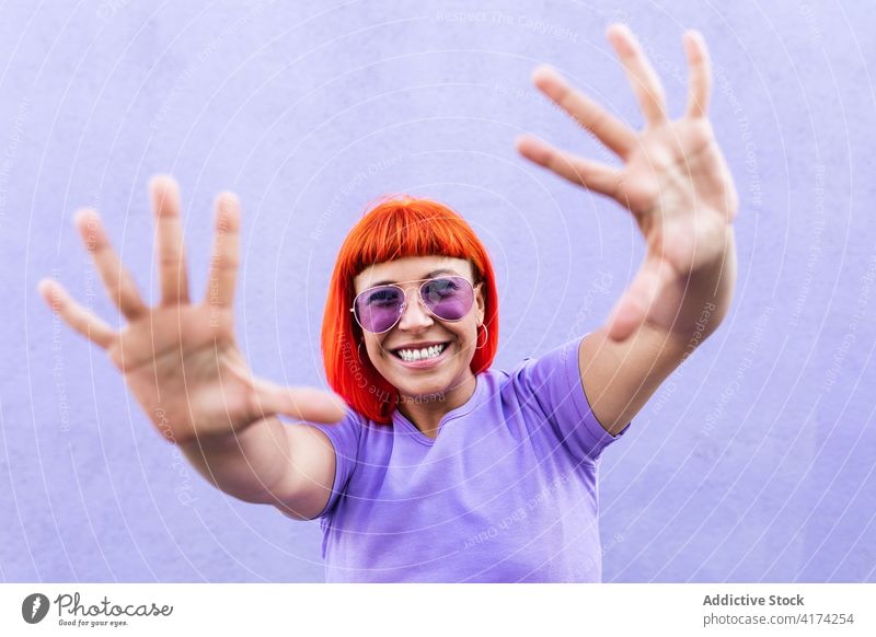 Glückliche stilvolle Frau mit Händen auflehnen Subkultur Stil Straße ausdehnen Lächeln farbenfroh hell Erwachsener zeigen manifestieren Hand Rotschopf Ingwer
