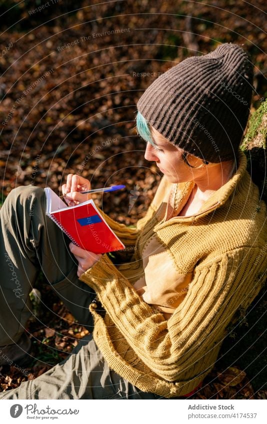 Reisende Frau macht sich Notizen in einem Notizbuch im Wald Reisender zur Kenntnis nehmen Wälder schreiben Notebook Tagebuch Urlaub Abenteuer Baum Kofferraum