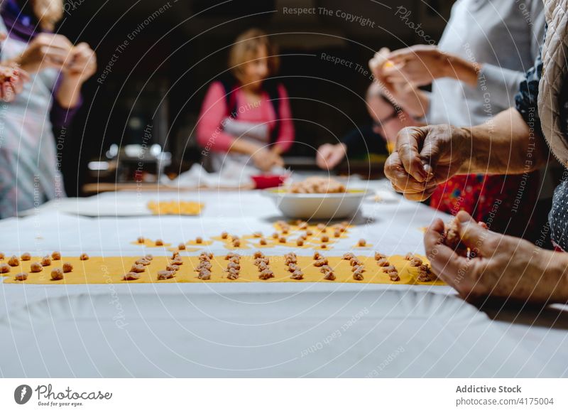 Crop-Frauen kochen traditionelle Tortellini in der Küche Koch vorbereiten Knödel Tradition Italienische Küche selbstgemacht Bestandteil Fleisch Teigwaren roh
