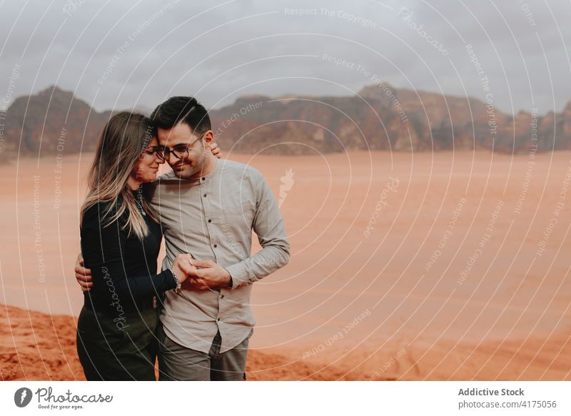 Verliebtes Touristenpaar, das sich in der Wüste umarmt Paar Reisender wüst Umarmung Sandstein Tal Zusammensein Angebot Urlaub genießen Wadi Rum Jordanien