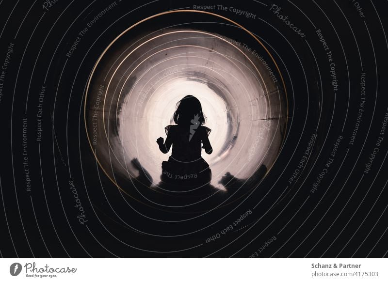 Kind rutscht durch eine Rutschröhre auf dem Spielplatz Kleid Mädchen Rutsche Röhre Tunnel trauen mutig überwinden Licht am Ende des Tunnels Pipeline Rohr Mut