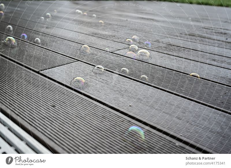 Seifenblasen auf den Terrassendielen spielen Kind Kinder Kindheit Balkon Garten Bubble Holzbretter Dielen Freude Glück zerplatzen Träume