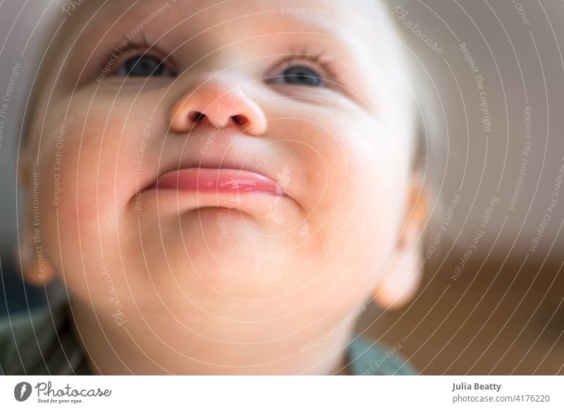 Blick auf das Gesicht eines niedlichen, pausbäckigen Kleinkindes; Unterlippe vorgeschoben und Augen himmelwärts gerichtet Baby Kind Porträt Lippen Nasenloch