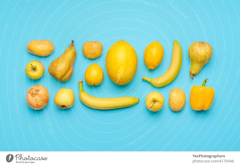 Gelbe Früchte und Gemüse isoliert auf einem blauen Hintergrund. oben ausgerichtet Apfel Banane hell Zitrusfrüchte Sammlung farbenfroh Farben Textfreiraum