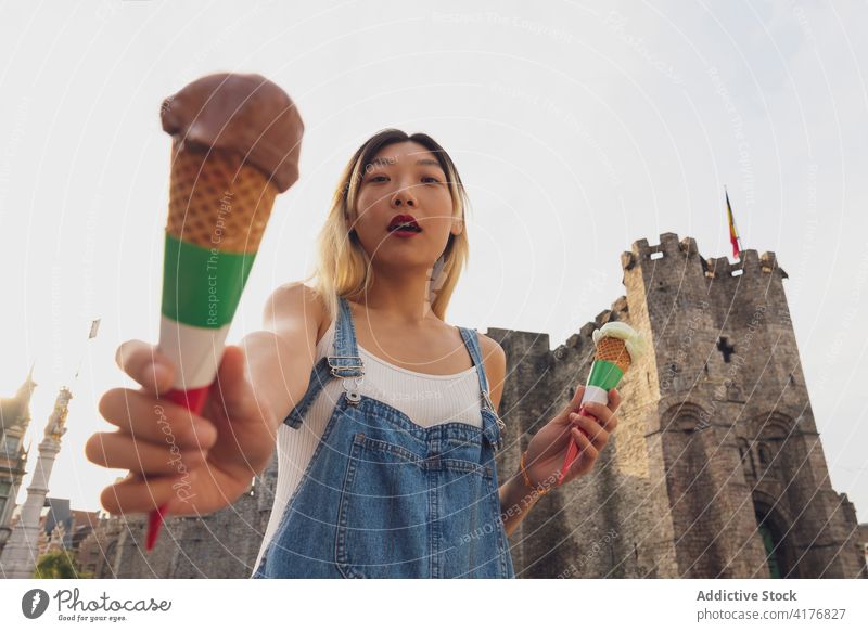 Ethnische Frau mit Eiscreme in Tüten auf der Straße Speiseeis Zapfen Sommer Baggerlöffel Leckerbissen Großstadt schlendern Erfrischung ethnisch asiatisch süß