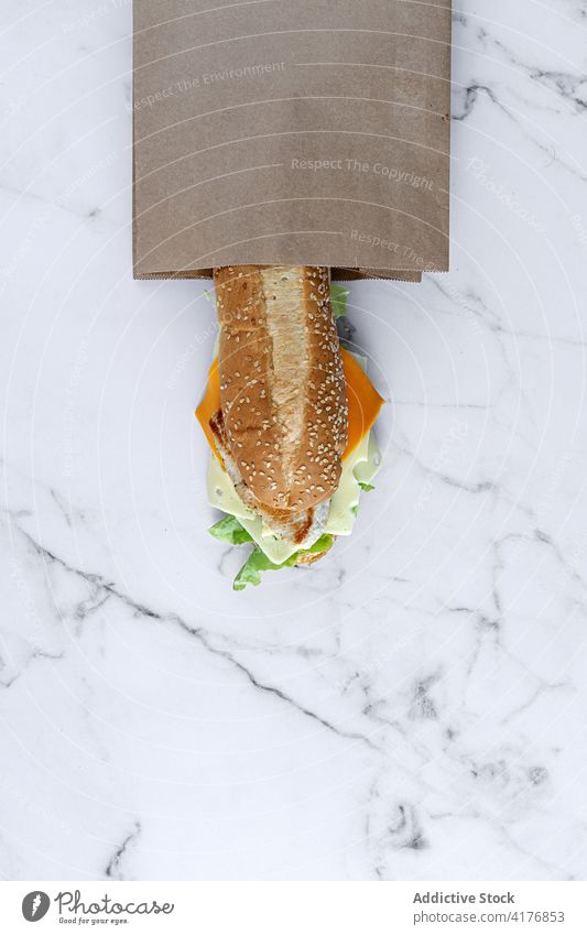 Leckeres Sandwich in Papiertüte auf dem Tisch Belegtes Brot Tüte Imbissbude Lebensmittel zum Mitnehmen Käse geschmackvoll Mahlzeit frisch lecker Gemüse