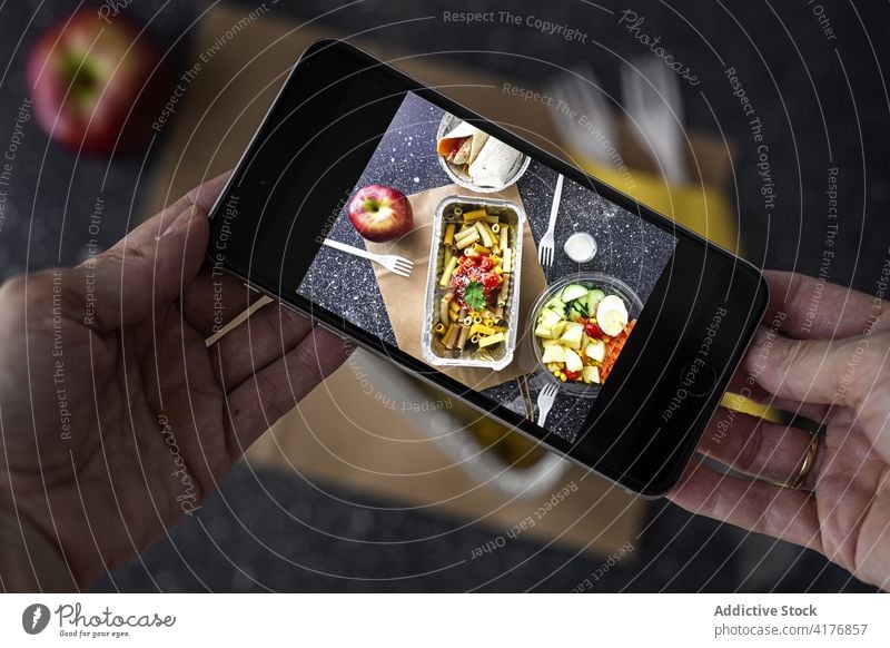 Person, die ein Foto von Essen zum Mitnehmen macht Food-Fotografie fotografieren Imbissbude Blogger Smartphone Mittagessen soziale Netzwerke Lebensmittel