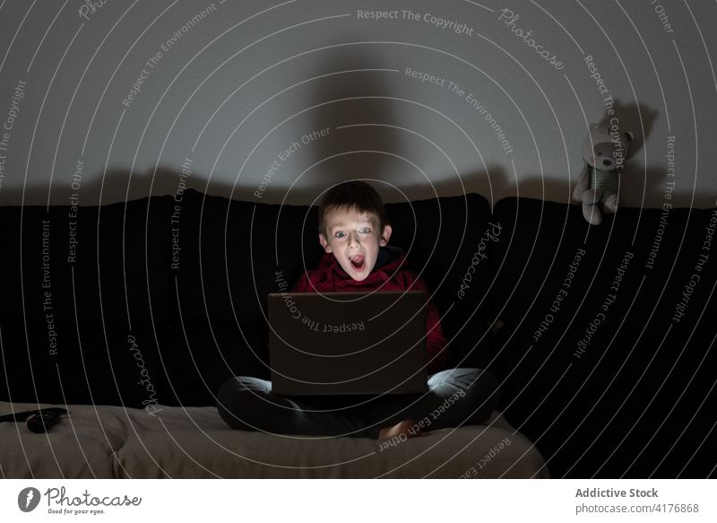 Kind schaut Film auf Laptop zuschauen dunkel Filmmaterial Video Nacht Junge allein zu Hause Lifestyle online erschrecken digital Abend interessant benutzend