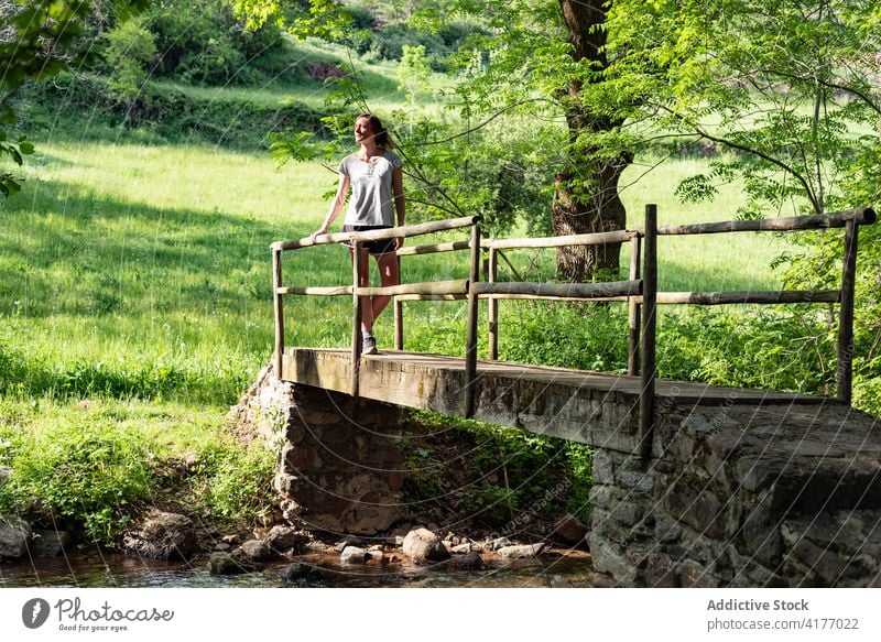 Frau entspannt auf Brücke im Wald Wälder Sommer sich[Akk] entspannen Fluss genießen sorgenfrei Natur friedlich ruhen Baum stehen Freiheit Wasser Bach alt ruhig