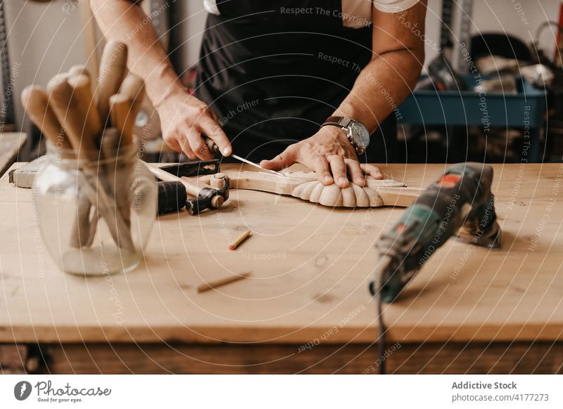 Handwerker schnitzt Holz mit Meißel Zimmerer Holzarbeiten schnitzen Beitel Arbeit kreieren Instrument professionell Werkstatt Werkzeug Mann hölzern Arbeitsplatz