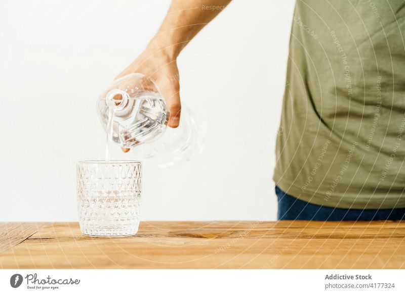 Mann gießt Wasser in ein Glas Flasche eingießen besetzen frisch rein trinken Mineral Getränk übersichtlich Kunststoff liquide Durst Gesundheit Hydrat