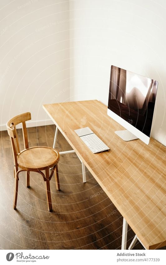 Minimalistischer Arbeitsplatz mit modernem Computer sehr wenige Tisch Stuhl Innenbereich Möbel Schreibtisch einfach Stil Gerät Arbeitsbereich Apparatur Business