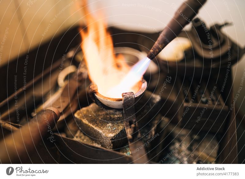 Prozess des Schmelzens von Metall in einer Schmuckwerkstatt zerlaufen Brenner Flamme professionell Werkstatt Werkzeug Goldschmied Herstellung Inszenierung Gerät