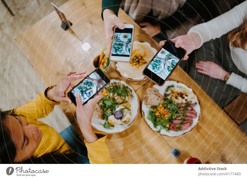Gesellschaft von Frauen, die Fotos von Lebensmitteln in einem Café machen Food-Fotografie Blogger fotografieren Zusammensein Smartphone soziale Netzwerke Speise