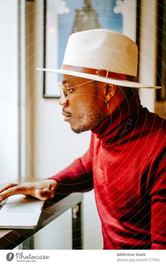 Stilvoller schwarzer Geschäftsmann im Cafe am Computer Mann Café Unternehmer elegant abgelegen männlich ethnisch Hut Afroamerikaner trendy Pause Arbeit