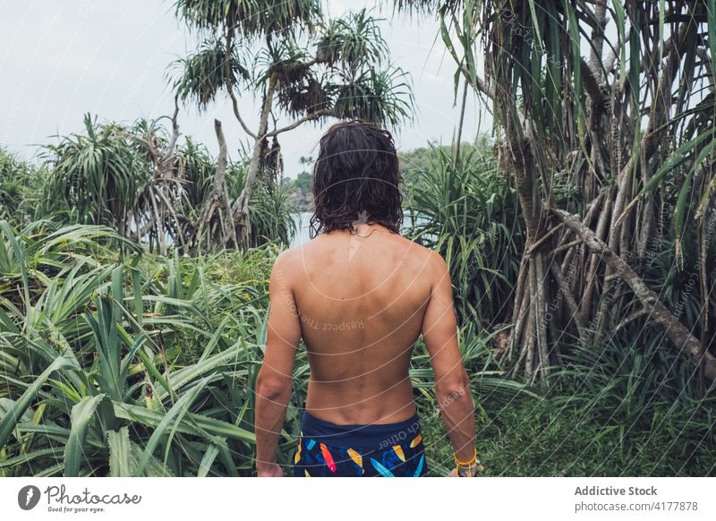 Anonymer ethnischer Mann ohne Hemd im Dschungel stehend MEER tropisch exotisch Natur Reisender männlich Tourismus Bucht reisen Sri Lanka hiriketiya grün Küste