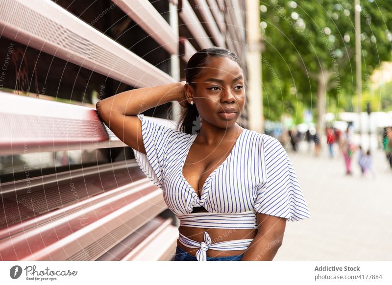 Schwarze Frau in modischer Kleidung schaut auf der Straße weg Stil trendy Outfit modern urban Streifen jung Sommer Afroamerikaner schwarz ethnisch Windstille