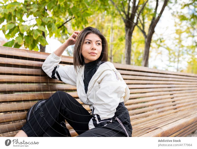 Ethnische Frau entspannt sich auf einer Bank im Park besinnlich träumen nachdenklich sich[Akk] entspannen ruhen ruhig jung verträumt Latein ethnisch Lifestyle