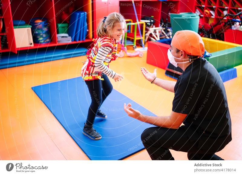 Betreuerin spielt mit Kind mit Behinderung deaktivieren Syndrom Therapie Entwicklung spielen Aktivität abstützen Erkrankung Engelmann Übung Mädchen