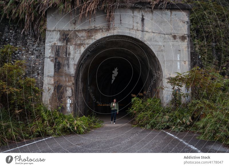 Reisender geht durch einen gewölbten Tunnel Stollen Straße Durchgang verwittert Stein Weg eng Route Tourismus reisen Spaziergang Gebäude Konstruktion Bogen