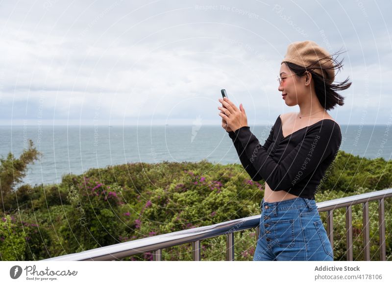 Junge Frau beim Fotografieren einer Meereslandschaft MEER fotografieren Smartphone Reisender Aussichtspunkt Mobile einfangen Telefon schießen digital Natur