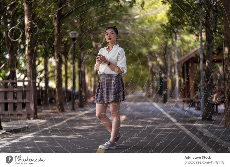 Asiatische Frau zu Fuß entlang Fahrradweg Weg Spaziergang Fahrspur Smartphone Browsen Großstadt Nachricht ethnisch asiatisch tanya shen green bikeway Taichung