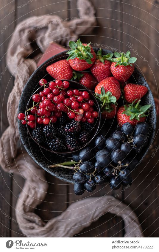 Leckere Früchte und Beeren in einer Schale auf dem Tisch Ernte Frucht Schalen & Schüsseln verschiedene rustikal Gesundheit alt süß Küche Handtuch geschmackvoll
