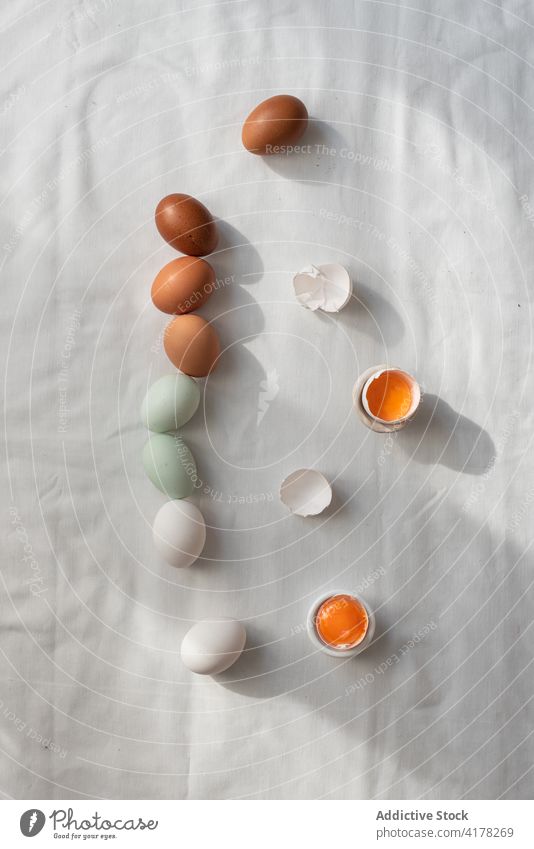 Bunte Eier auf weißem Tisch Reihe Küche Orden Eigelb roh Ostern Lebensmittel beige braun farbenfroh Tradition Ordnung Bestandteil kulinarisch Mahlzeit Ernährung
