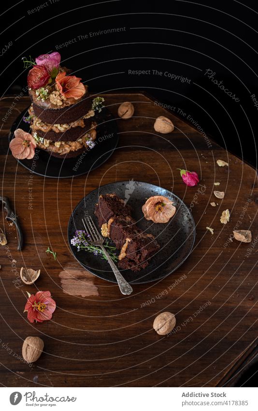 Leckerer Schokoladenkuchen mit Walnüssen am Tisch serviert Kuchen Walnussholz Blume Spielfigur dienen rustikal Dessert süß Lebensmittel festlich geschnitten