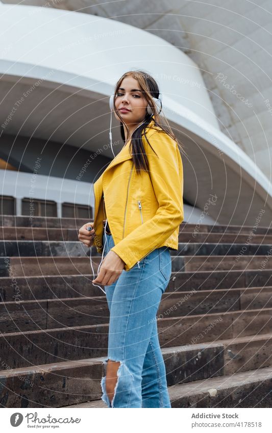 Hipster-Frau mit Kopfhörern auf der Straße stehend trendy zuhören urban Stil Treppe Musik jung Jeanshose Jeansstoff Apparatur Gerät Lifestyle genießen Optimist