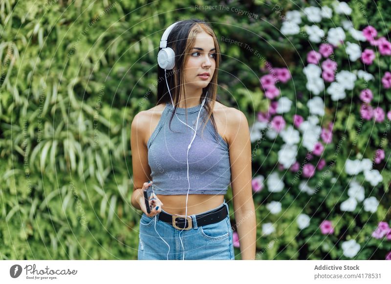 Frau mit Smartphone und Kopfhörern chillt im Park zuhören Spaß haben heiter Sommer Telefon Mobile Musik jung Apparatur Gerät Lifestyle genießen benutzend