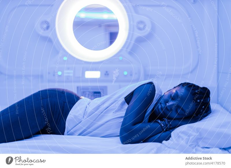 Reisender schläft im modernen Kapselhotel Frau Hotel schlafen Bett ruhen Unterkunft sich[Akk] entspannen Nacht jung Afroamerikaner schwarz ethnisch Lifestyle