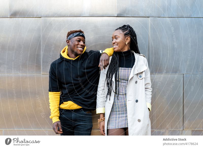 Stilvoller schwarzer Mann und Frau stehen in der Nähe eines modernen Gebäudes Paar trendy besinnlich nachdenklich urban Mode tausendjährig Hipster jung