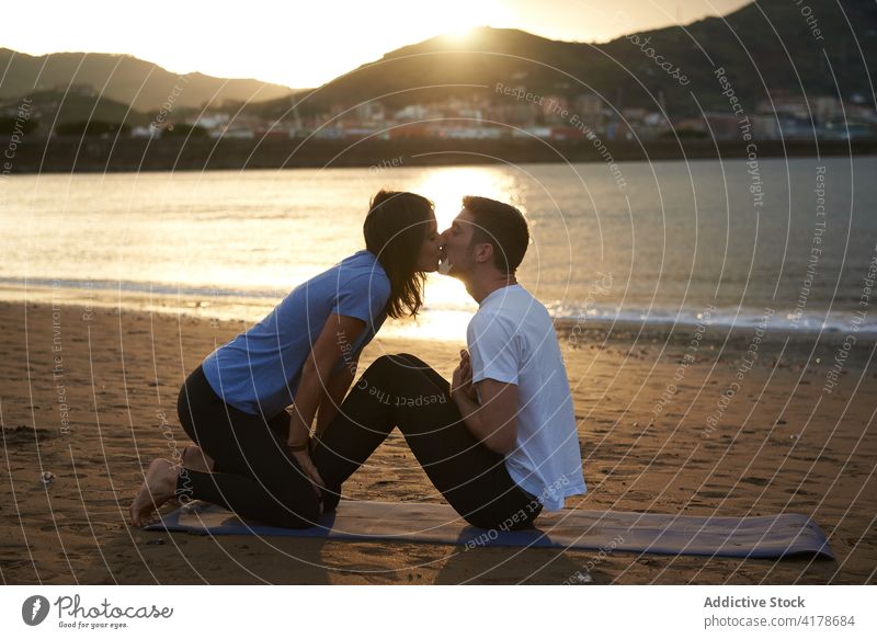 Paar macht Yoga und küsst sich am Meeresstrand Kuss Zusammensein üben Liebe MEER Strand Asana Pose Sportkleidung Natur Harmonie Partnerschaft Seelenverwandter