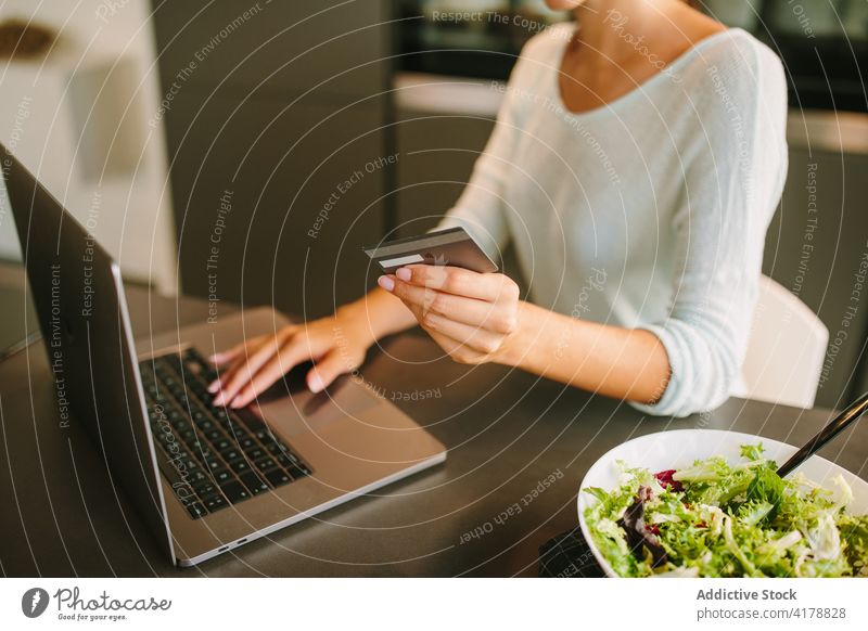 Unbekannte Frau beim Online-Einkauf am Laptop zu Hause Kreditkarte online Kauf benutzend Zahlung Orden Internet jung Apparatur Gerät e-Commerce Anschluss