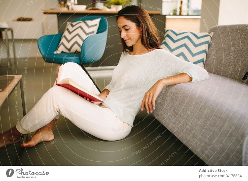 Frau liest Buch im Wohnzimmer zu Hause lesen ruhen Sofa Wochenende gemütlich jung Freizeit Literatur interessant Liege sich[Akk] entspannen Etage Roman