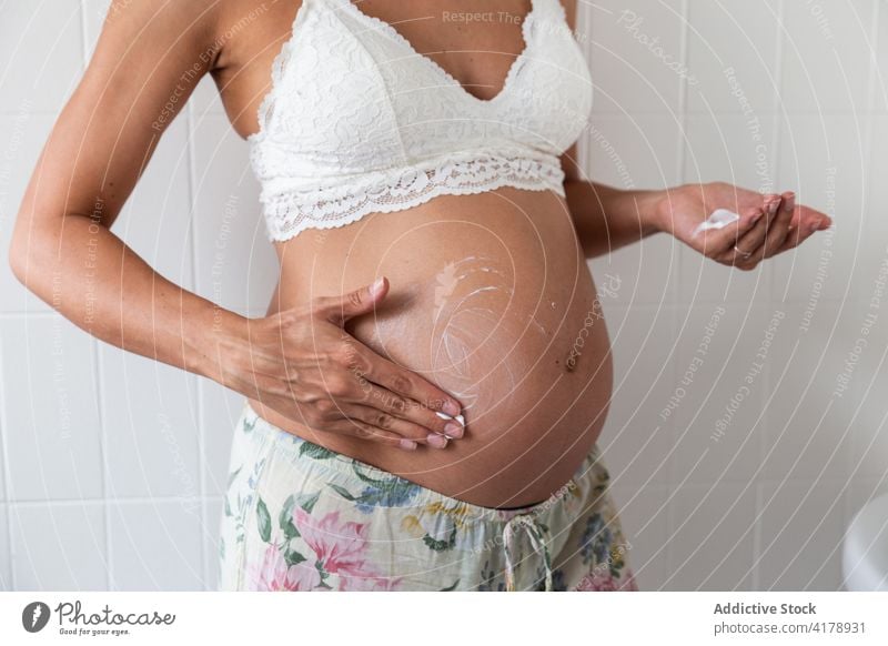 Schwangere Frau beim Eincremen des Bauches schwanger Körperpflege bewerben Sahne Hautpflege Schwangerschaft Feuchtigkeit Produkt Bad BH mütterlich Wohlbefinden