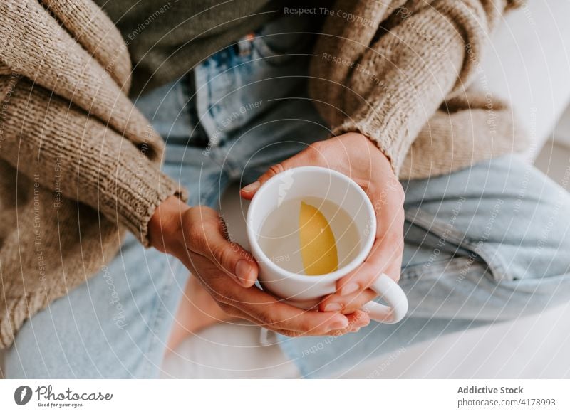 Crop-Frau mit Tasse Wasser mit Zitrone Entzug Diät Morgen Gesundheit Erfrischung trinken natürlich Scheibe heimwärts ruhen sitzen gemütlich organisch Ernährung