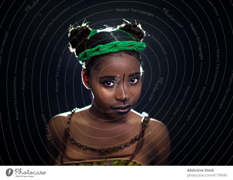 Junge schwarze Frau mit bemaltem Gesicht Mode Stil Farbe Gesichtsbehandlung Tradition farbenfroh Afrikanisch Stirnband Porträt Model Körperkunst ethnisch jung