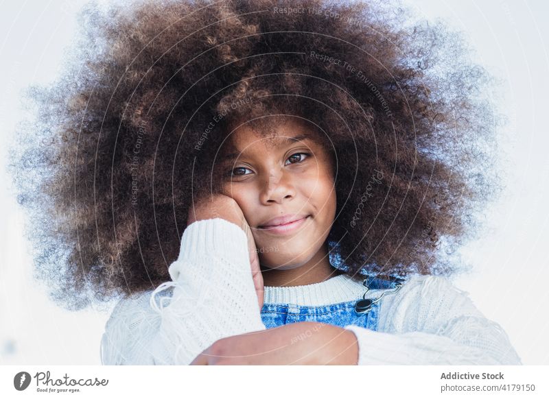 Lächelndes schwarzes Teenager-Mädchen mit lockigem Haar Afro-Look Kind krause Haare positiv Jeansstoff Porträt Frisur Frau Afroamerikaner ethnisch heiter Inhalt