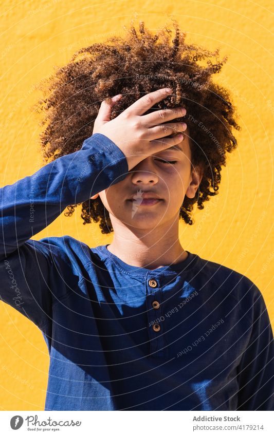 Afroamerikanischer Junge schlägt sich auf die Stirn enttäuschen vergessen Klaps Fehler Denken krause Haare Kind verwirren Problematik Afro-Look schwarz ethnisch