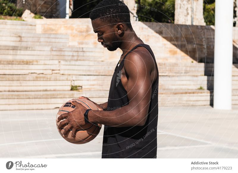 Seriöser schwarzer Mann mit Basketball auf Sportplatz Ball Sportpark Spieler Bestimmen Sie Sommer Sonnenbrille männlich ethnisch Afroamerikaner Sportbekleidung